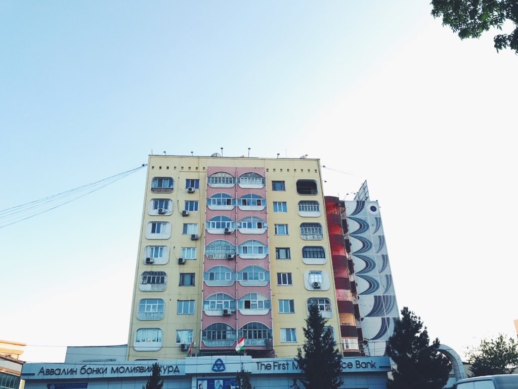 An old Soviet apartment building with windows shaped as the traditional Central Asian nomad home - a jurt